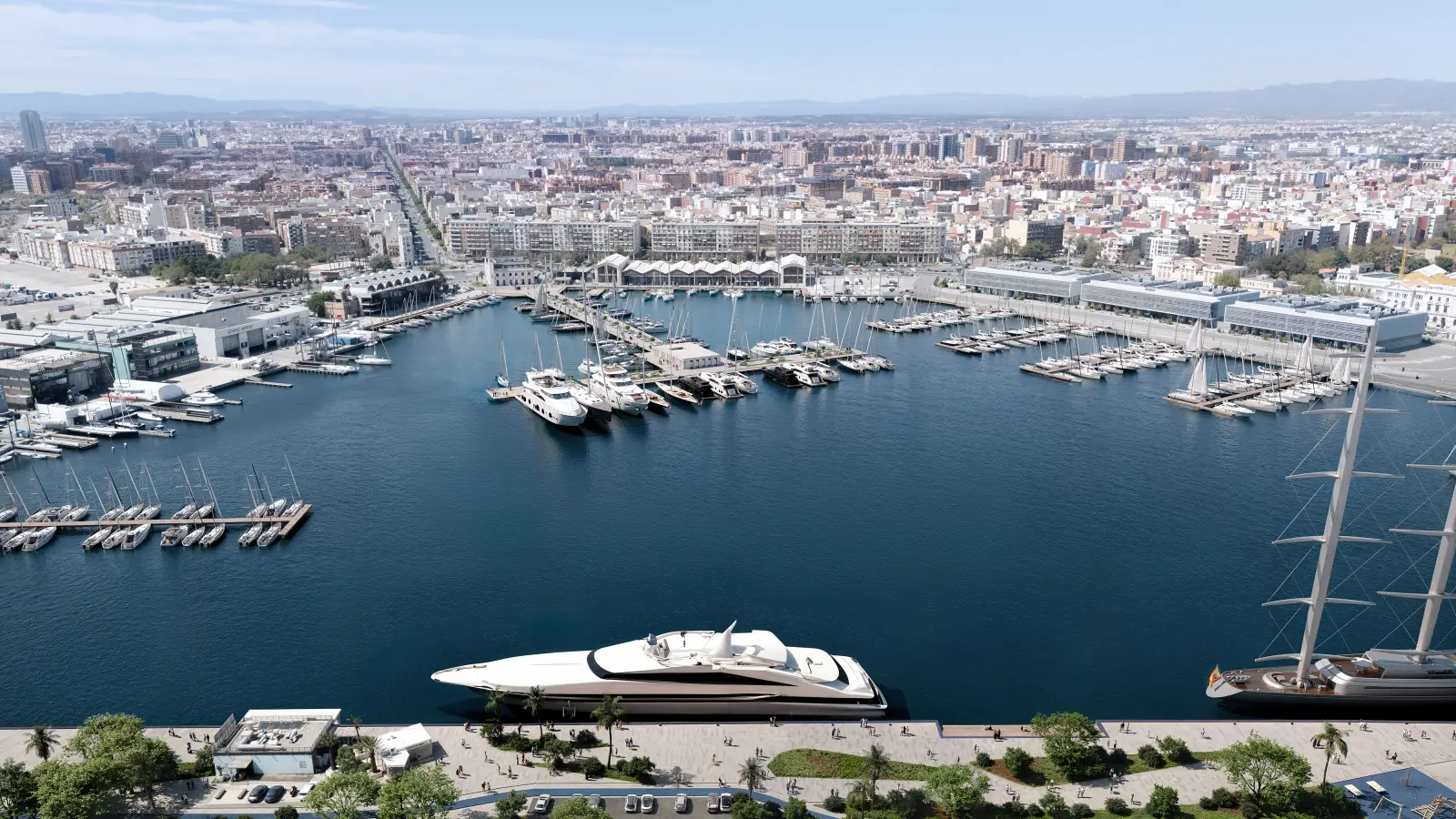 The marina basin from above, a superyacht alongside the quay and the city behind